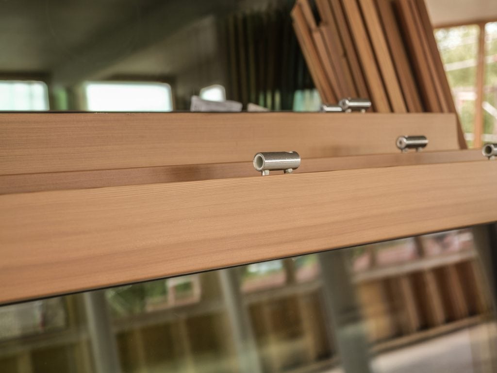 Detailaufnahme eines Holzfensters mit Glas und Metallbeschlägen im Belsers Hotel Nürtingen – nachhaltige Bauweise mit natürlichen Materialien.