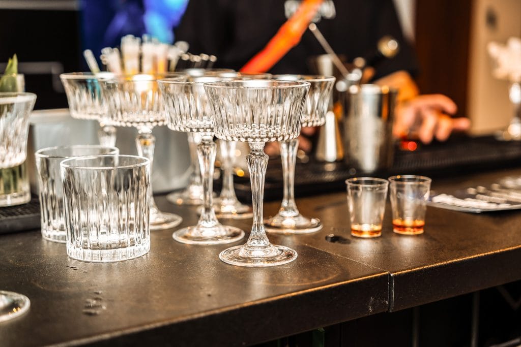 Elegante Cocktailgläser und Bar-Accessoires auf einer Hotelbar, perfekt für einen Feierabenddrink oder besondere Anlässe im Belsers Hotel.