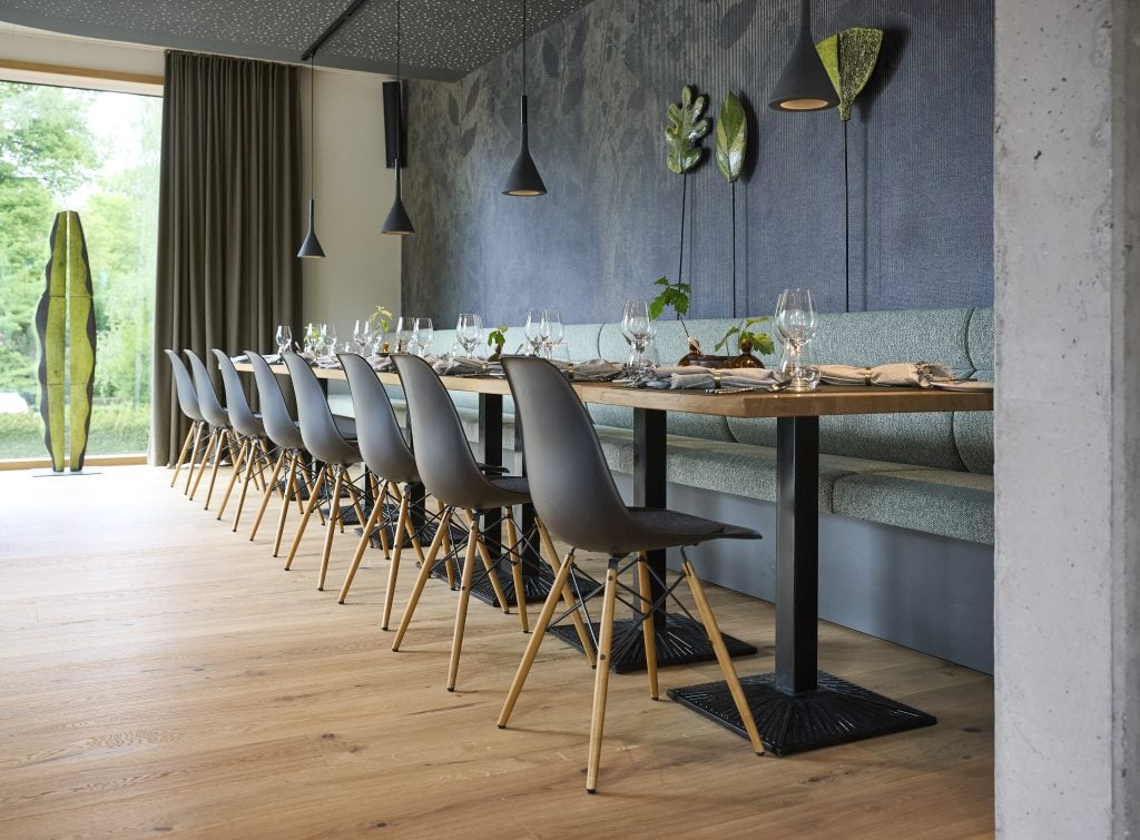 Moderne Speiseraumgestaltung im Belsers Hotel mit stilvollem Tisch, eleganten Stühlen und dekorativen Wandakzenten, ideal für Gäste, die eine hochwertige kulinarische Erfahrung suchen.
