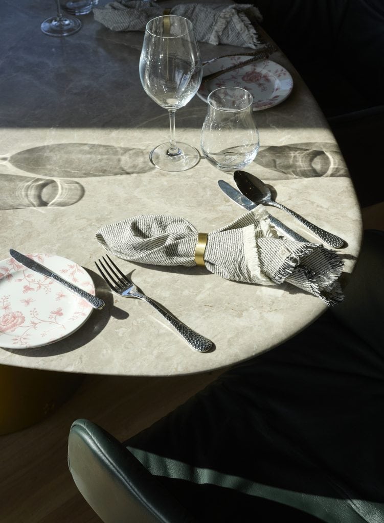 Stilvoll gedeckter Tisch im Belsers Hotel mit Wein- und Wassergläsern, Besteck und Servietten, ideal für ein feines Dinner oder eine besondere Veranstaltung.
