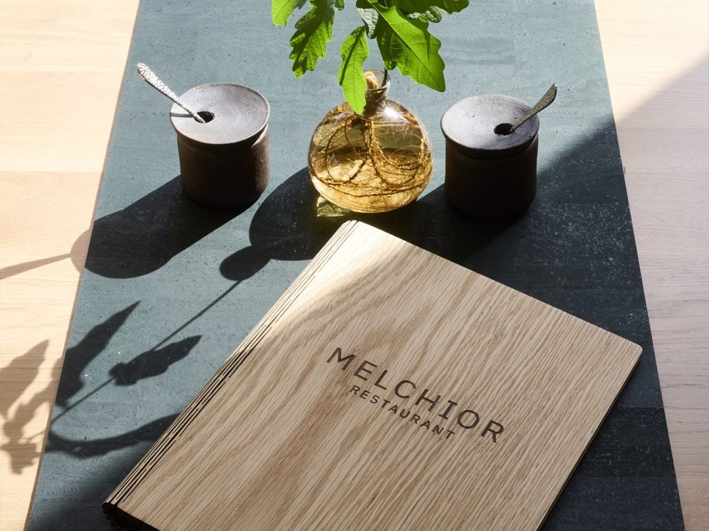 Hochwertiges Bild des Melchior Restaurants mit stilvoller Tischdekoration, ideal für Gäste, die ein feines Essen in einem eleganten Ambiente in Belsers Hotel suchen.