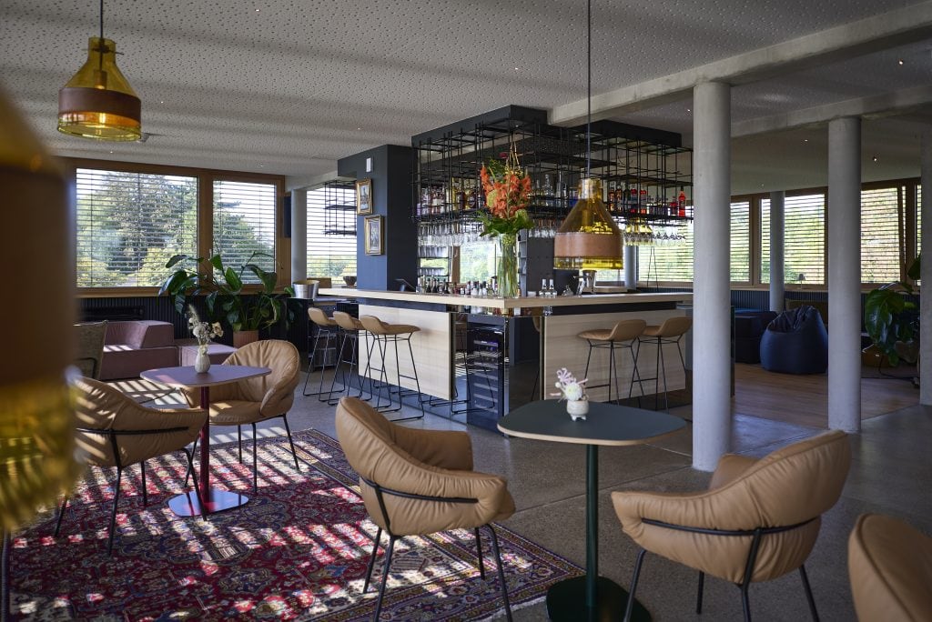 Moderne Hotel-Lounge im Belsers Hotel in Nürtingen mit stilvollen Sitzgelegenheiten, Barbereich und viel natürlichem Licht, ideal für Entspannung und Treffen.