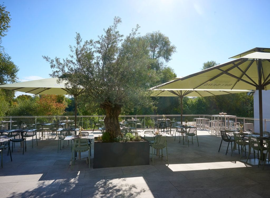 Terrasse im Belsers Hotel in Nürtingen mit Blick auf den Neckar, Sonnenschirme und Sitzgelegenheiten im Freien.